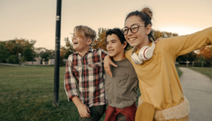 três adolescentes abraçados sorrindo