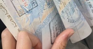 Mão folheando documento de visto